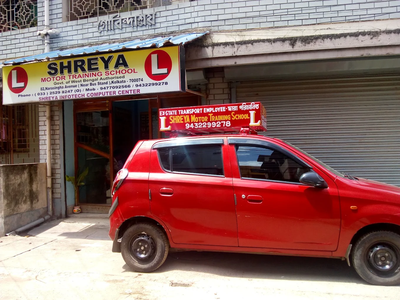 Red Shreya training car outside the school